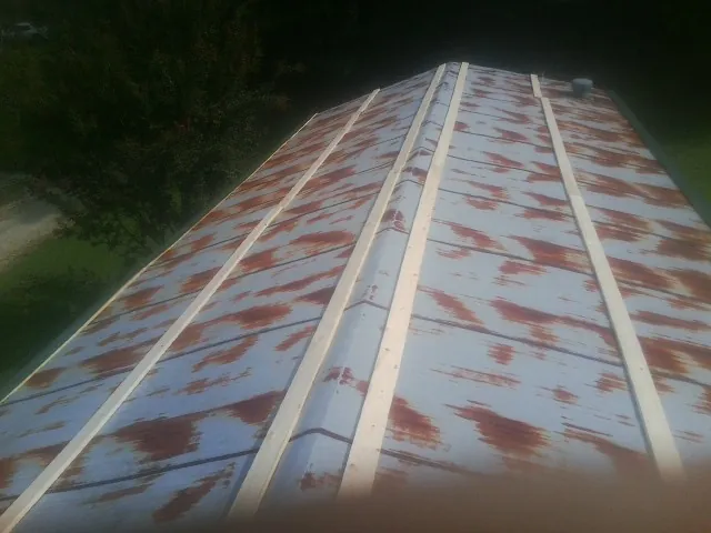 Rusted metal roof panels with new wood purlins before replacement — Storm Damage Roof Repair in Adelanto by Roofing Brothers