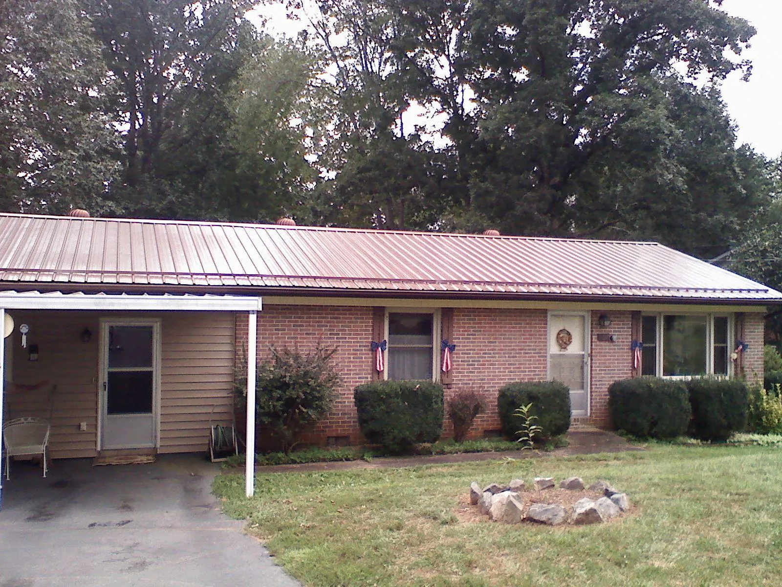 Bronze metal roof and carport on a brick ranch home — Roof Repair work by our crew in Adelanto